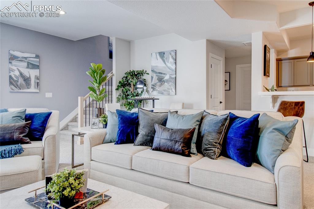 Image 15 of 19: Living area with recessed lighting and stairway