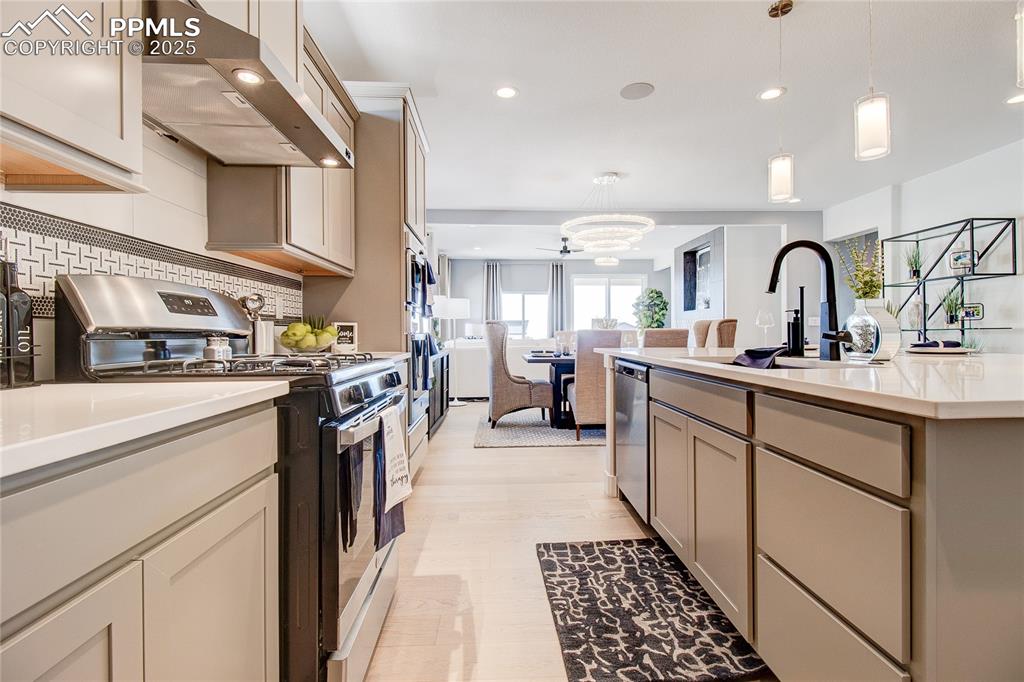 Image 6 of 19: Kitchen with exhaust hood, appliances with stainless steel finishes, light 