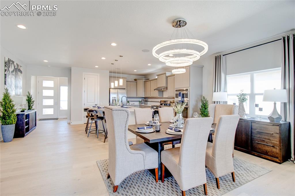 Image 9 of 19: Dining room featuring light wood-type flooring, a chandelier, and recessed 