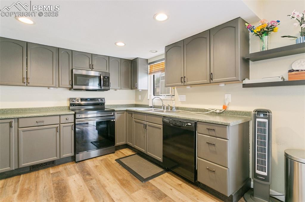 Image 10 of 26: Kitchen featuring appliances with stainless steel finishes, open shelves, l