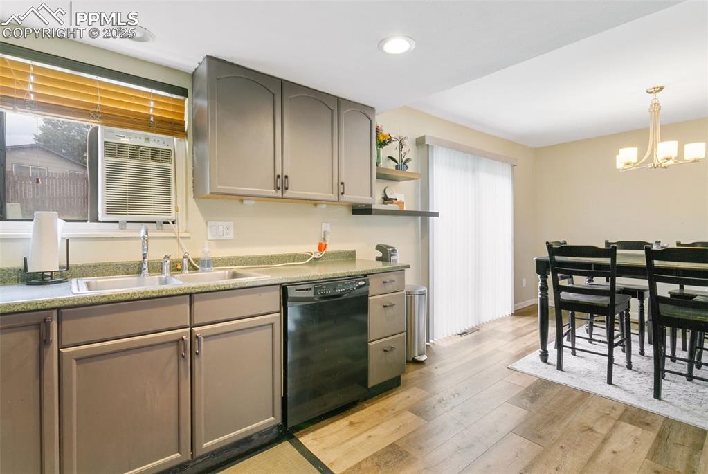 Image 11 of 26: Kitchen featuring a chandelier, light wood finished floors, dishwasher, ope
