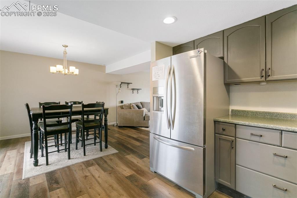 Image 12 of 26: Kitchen featuring stainless steel fridge, a chandelier, dark wood finished