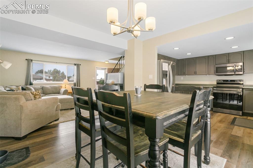 Image 13 of 26: Dining area featuring a chandelier, wood finished floors, and recessed ligh