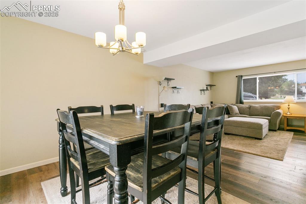 Image 14 of 26: Dining room with a chandelier and wood finished floors