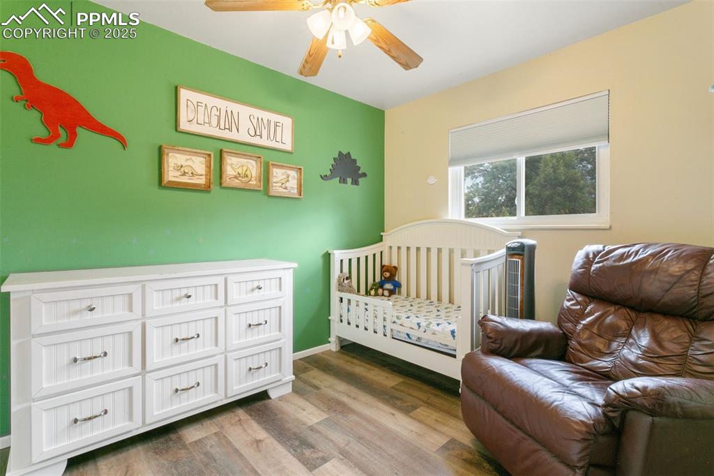 Image 17 of 26: Bedroom with wood finished floors and ceiling fan