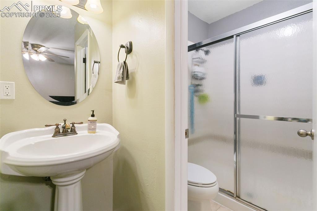 Image 22 of 26: Full bathroom featuring a stall shower and toilet