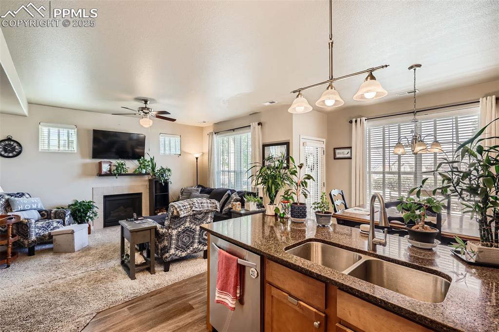 Image 11 of 26: Kitchen with open floor plan, brown cabinetry, dark wood-style floors, stai