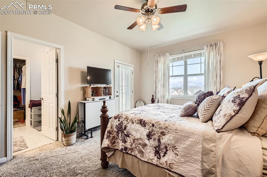 Image 14 of 26: Carpeted bedroom with a walk in closet and a ceiling fan