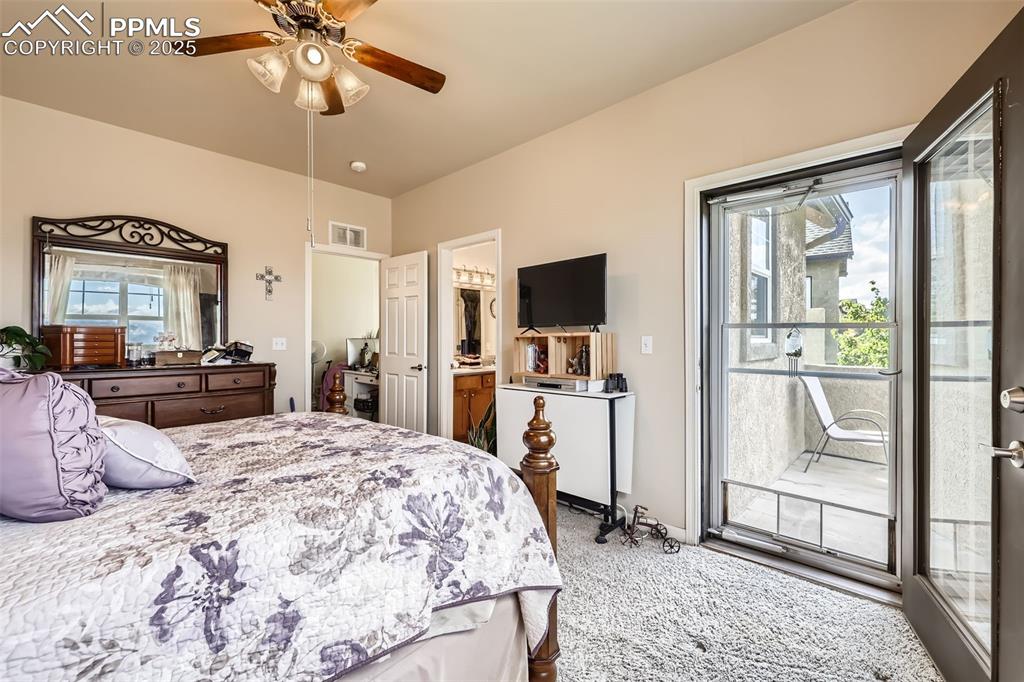 Image 15 of 26: Carpeted bedroom with access to outside, multiple windows, connected bathro