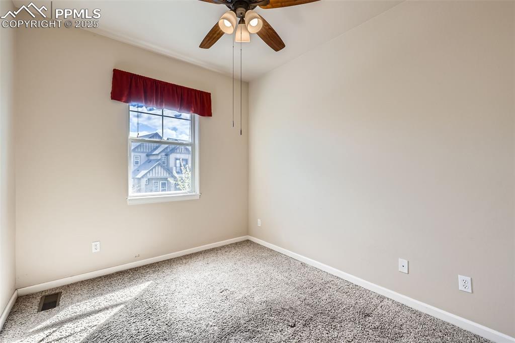 Image 17 of 26: Carpeted empty room with baseboards and ceiling fan