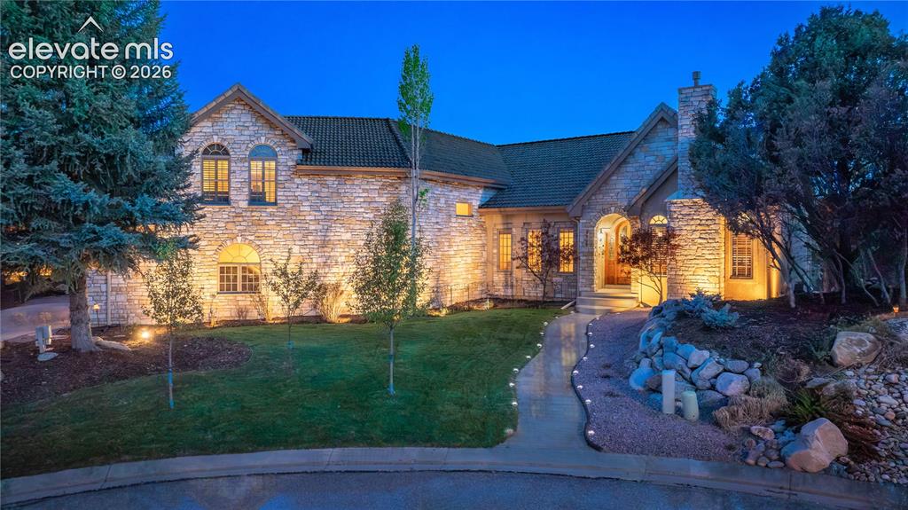 Image 1 of 50: Stone and stucco exterior with a tiled roof, featuring a two-car garage, es
