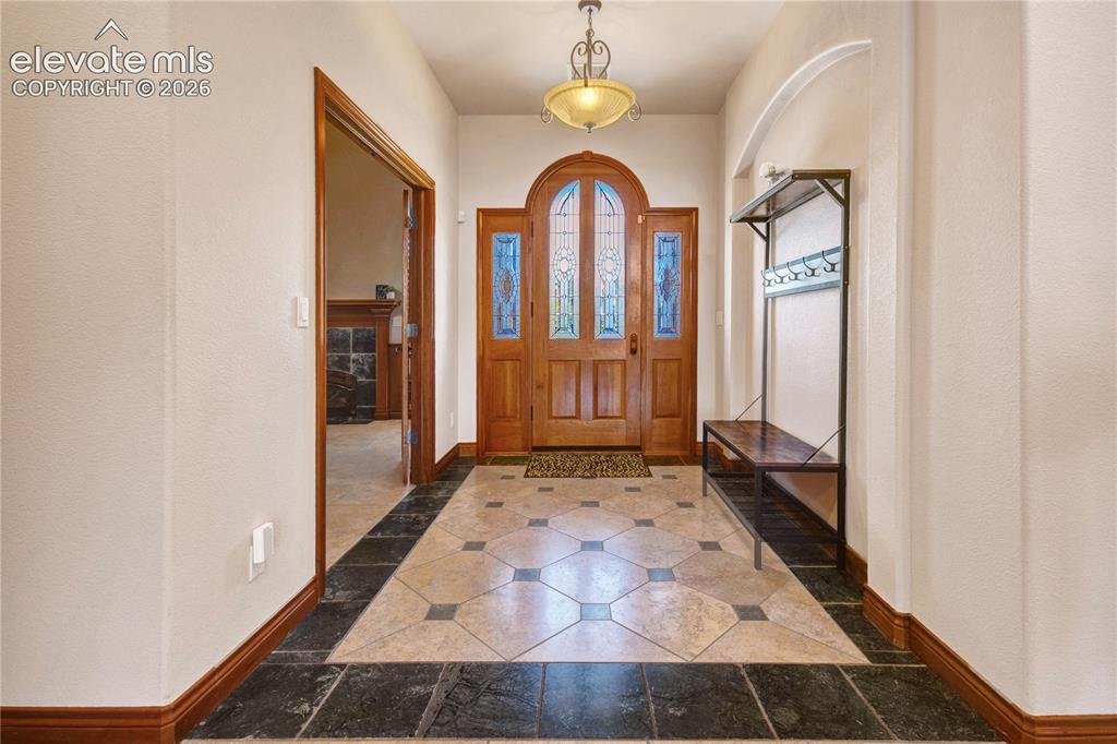 Image 10 of 50: Arched wooden entry door with leaded glass panels