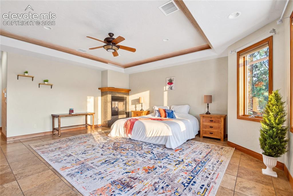 Image 23 of 50: Spacious room featuring tile flooring, a built-in fireplace with a stone su