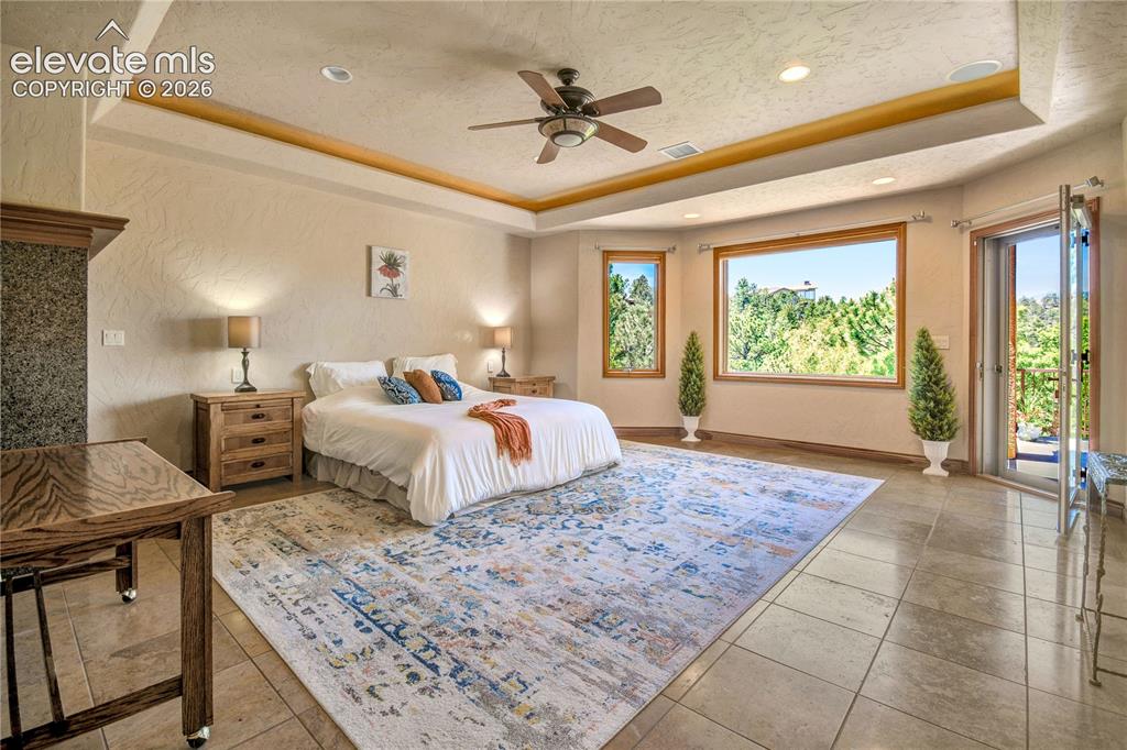 Image 24 of 50: Spacious room featuring multiple windows with natural wood trim, a tray cei