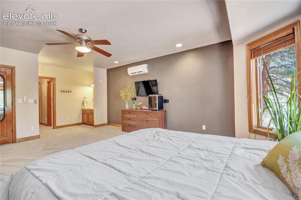 Image 41 of 50: Spacious room with carpet flooring, a wood-finish ceiling fan with integrat