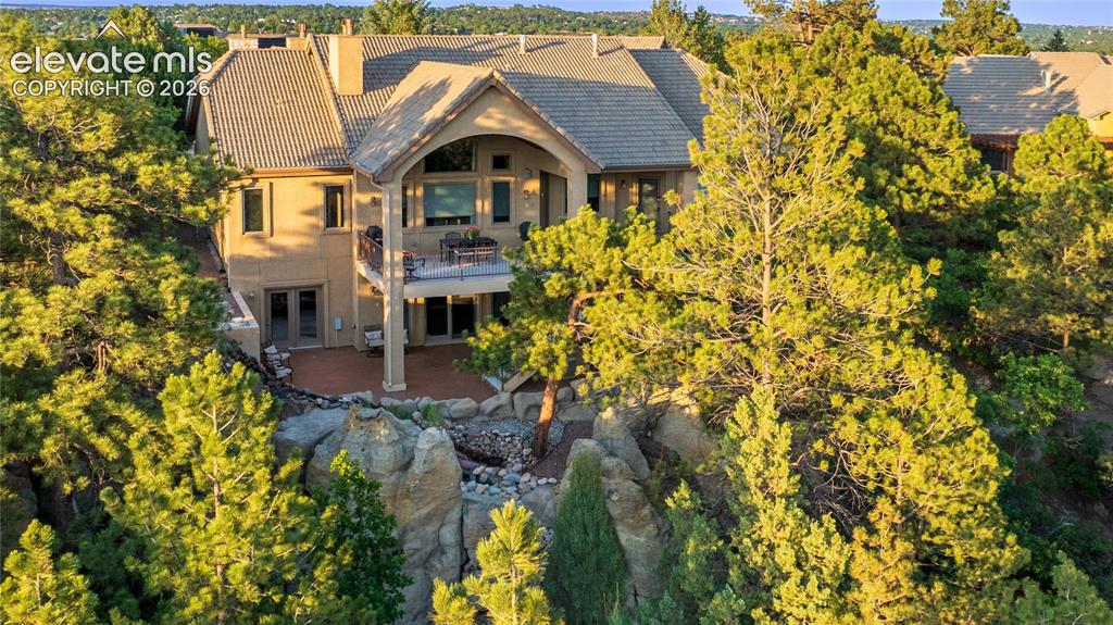 Image 6 of 50: Stone and stucco exterior with a tiled roof