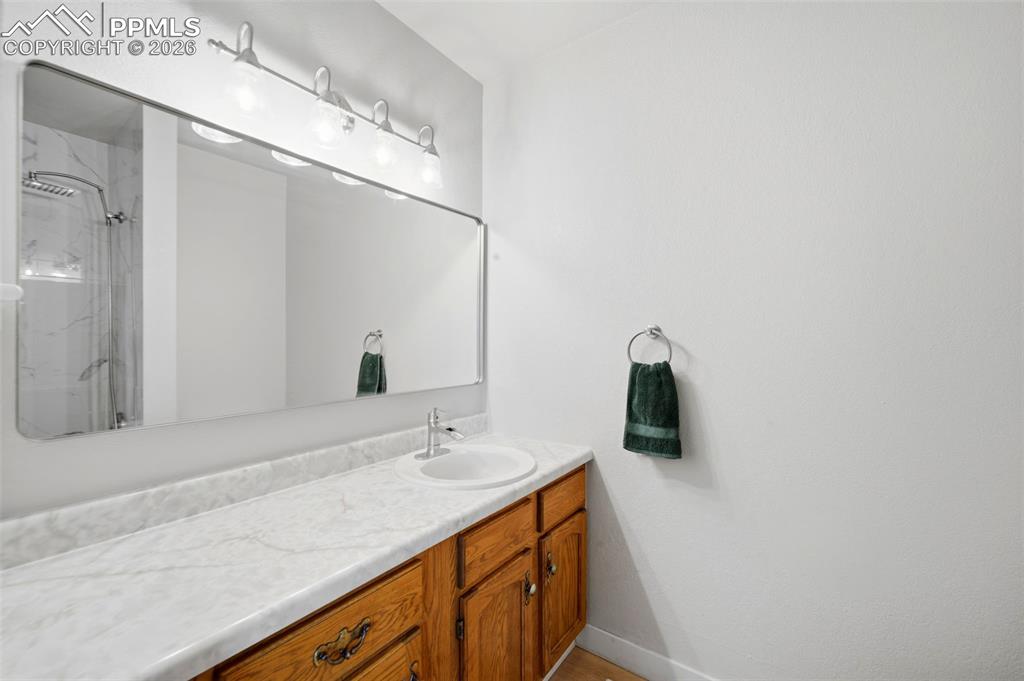 Image 13 of 37: Full bathroom with a marble finish shower and vanity