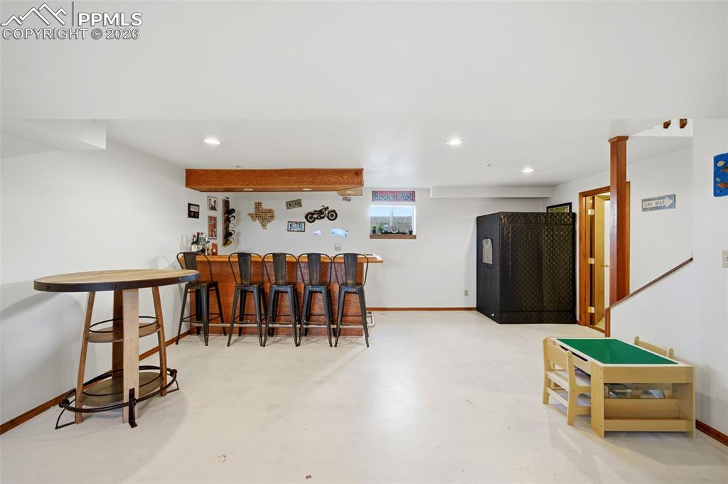 Image 20 of 37: Indoor dry bar featuring finished concrete flooring and recessed lighting