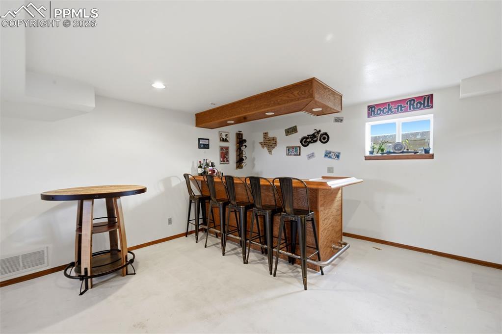 Image 21 of 37: Indoor dry bar featuring concrete floors and recessed lighting