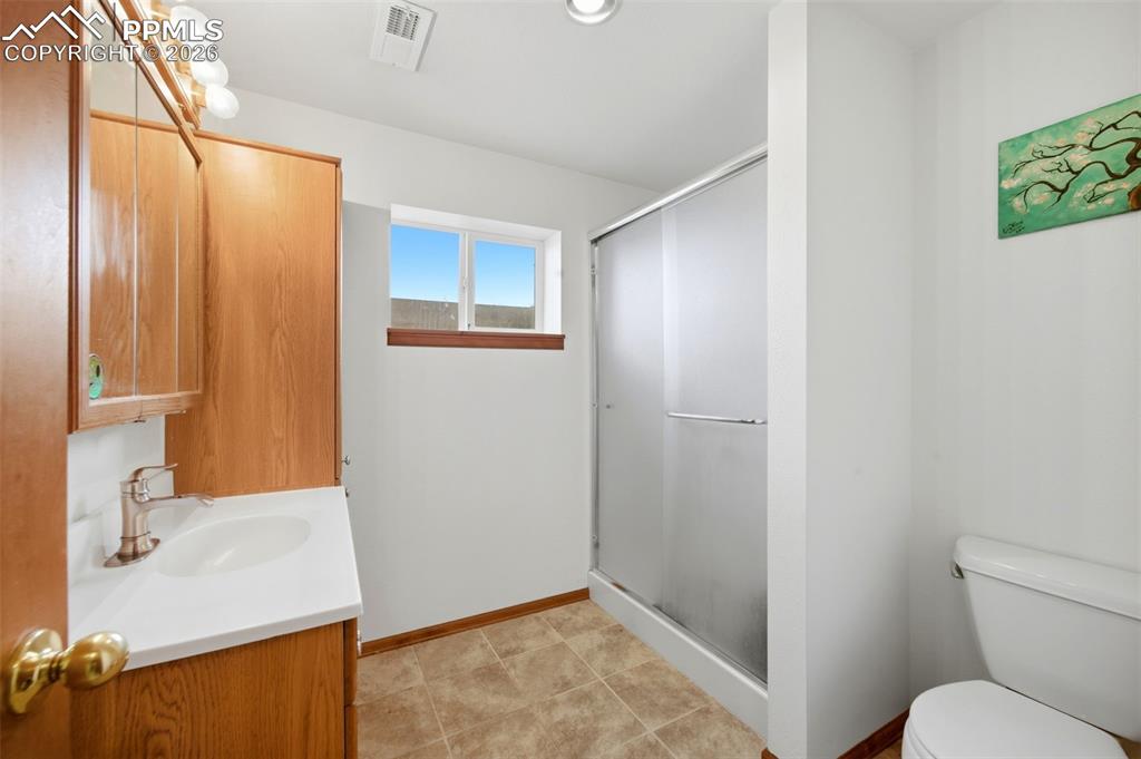 Image 24 of 37: Bathroom featuring vanity, a shower stall, and light tile patterned floors