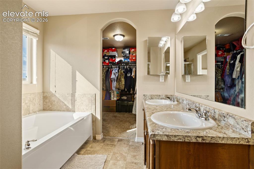 Image 14 of 30: Dual vanity with integrated sinks, framed mirrors, and overhead lighting