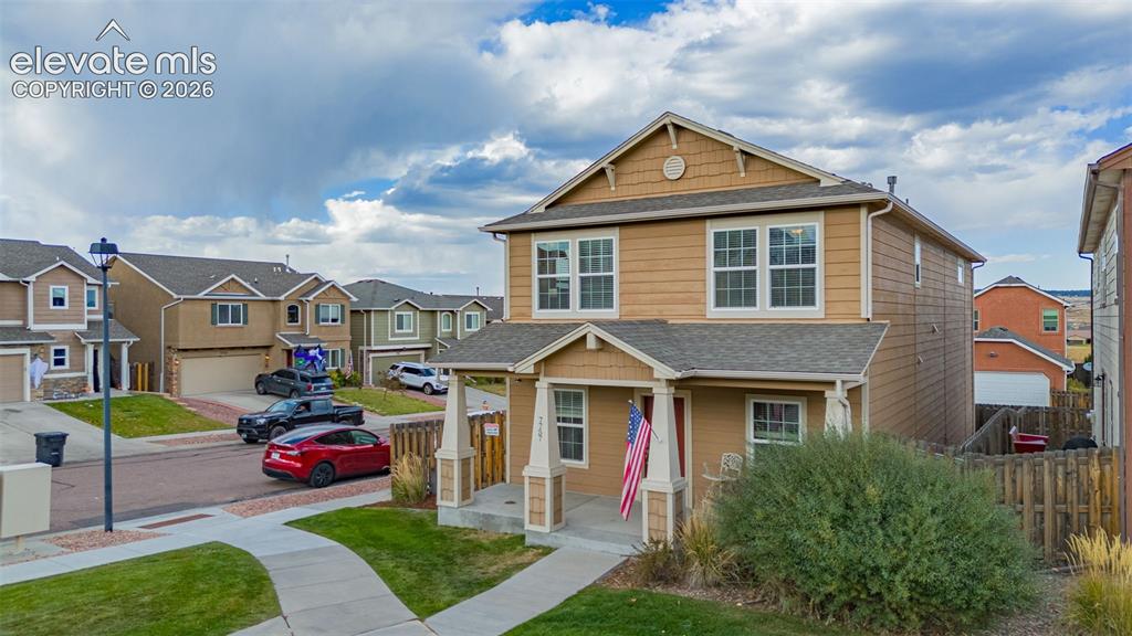Image 24 of 30: Two-story property with a covered porch, horizontal siding, and an attached