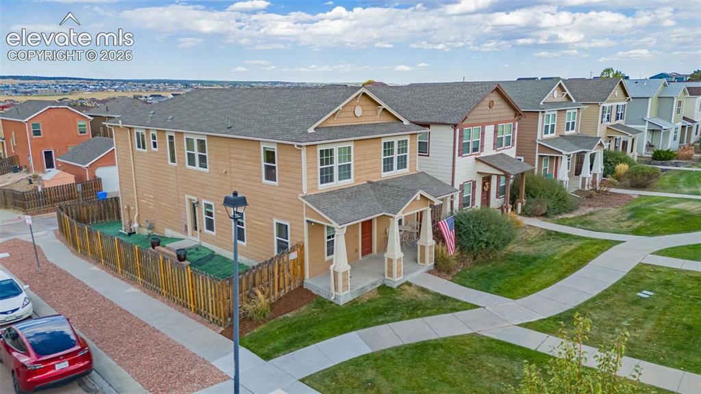 Image 26 of 30: Two-story residence with a covered front porch and a fenced side yard featu