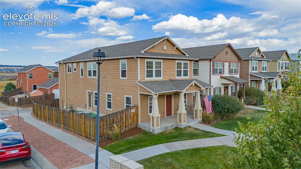 Image 27 of 30: Two-story exterior with a covered porch, gabled rooflines, and a fenced yar