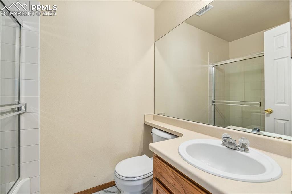 Image 12 of 27: Full bath featuring vanity and combined bath / shower with glass door