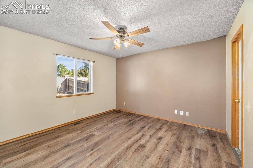 Image 15 of 27: Spare room featuring wood finished floors, a textured ceiling, and a ceilin