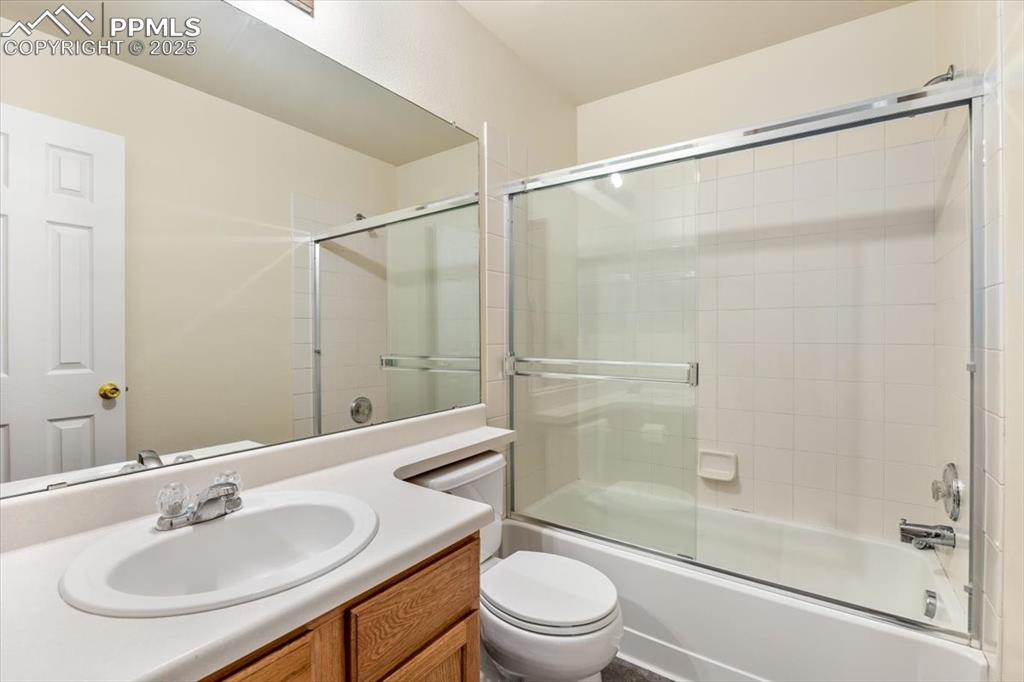 Image 16 of 27: Bathroom featuring combined bath / shower with glass door and vanity