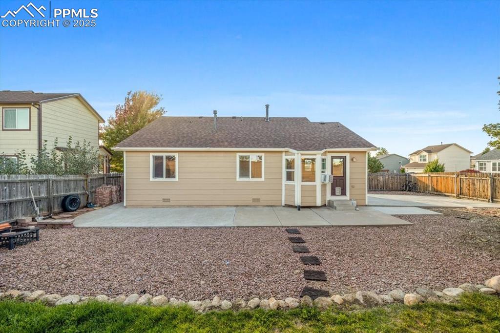 Image 18 of 27: Rear view of property with a patio, a fenced backyard, and a shingled roof
