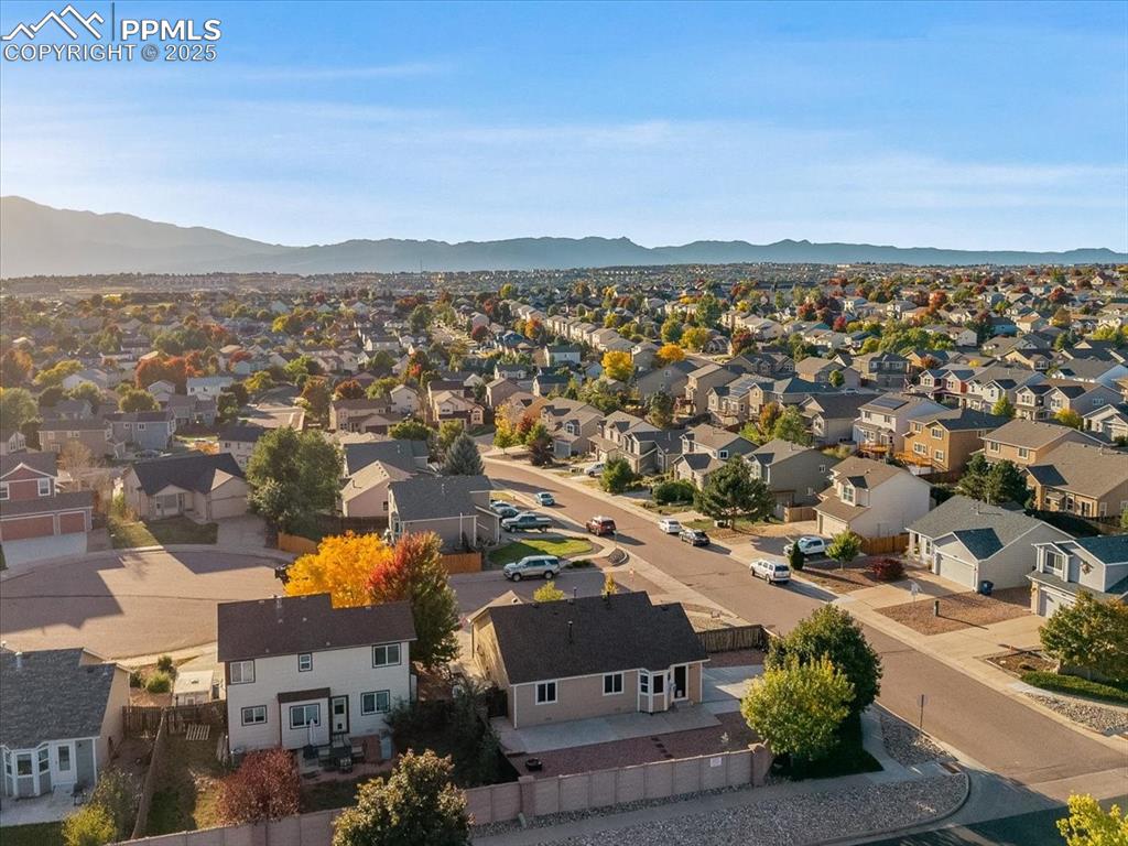 Image 23 of 27: Aerial view of residential area featuring a mountainous background