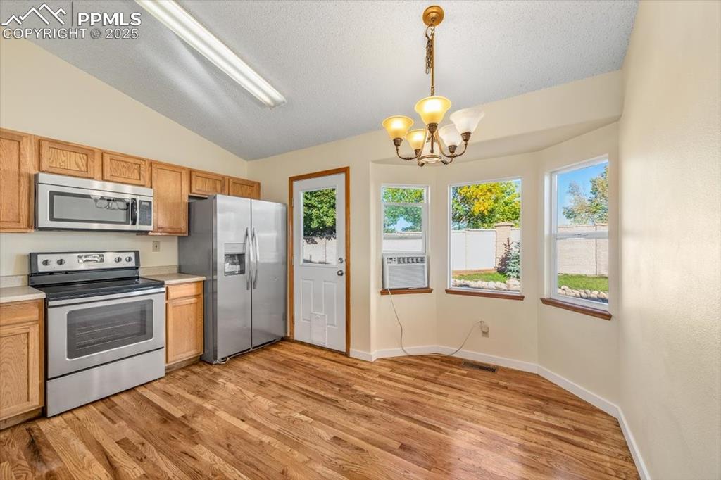 Image 4 of 27: Kitchen featuring appliances with stainless steel finishes, light counterto