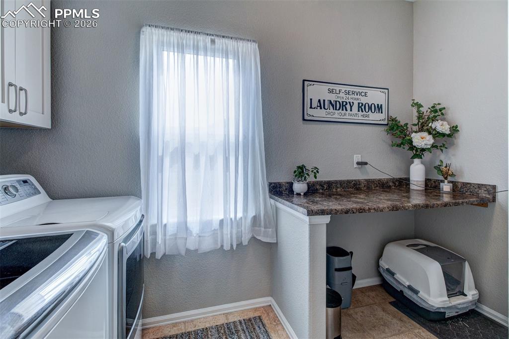 Image 15 of 32: Laundry room with convenient folding bench.