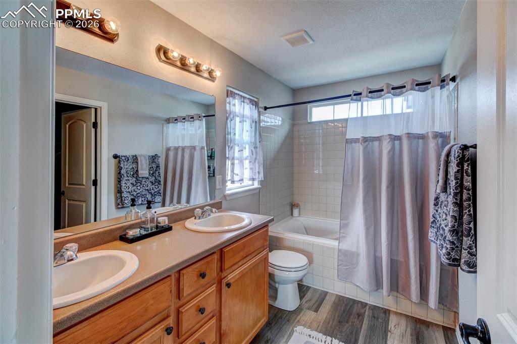 Image 24 of 32: Private full bath off of primary bedroom features laminate wood floors and 