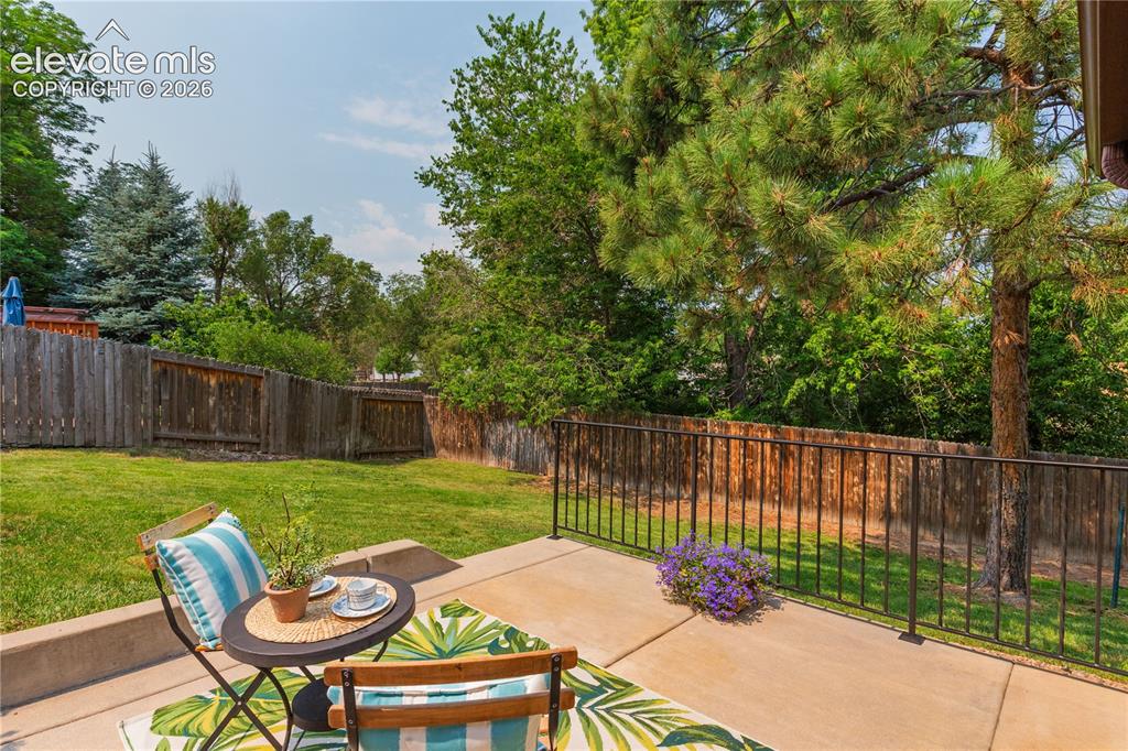 Image 17 of 50: Low-maintenance concrete patio features a black iron railing.