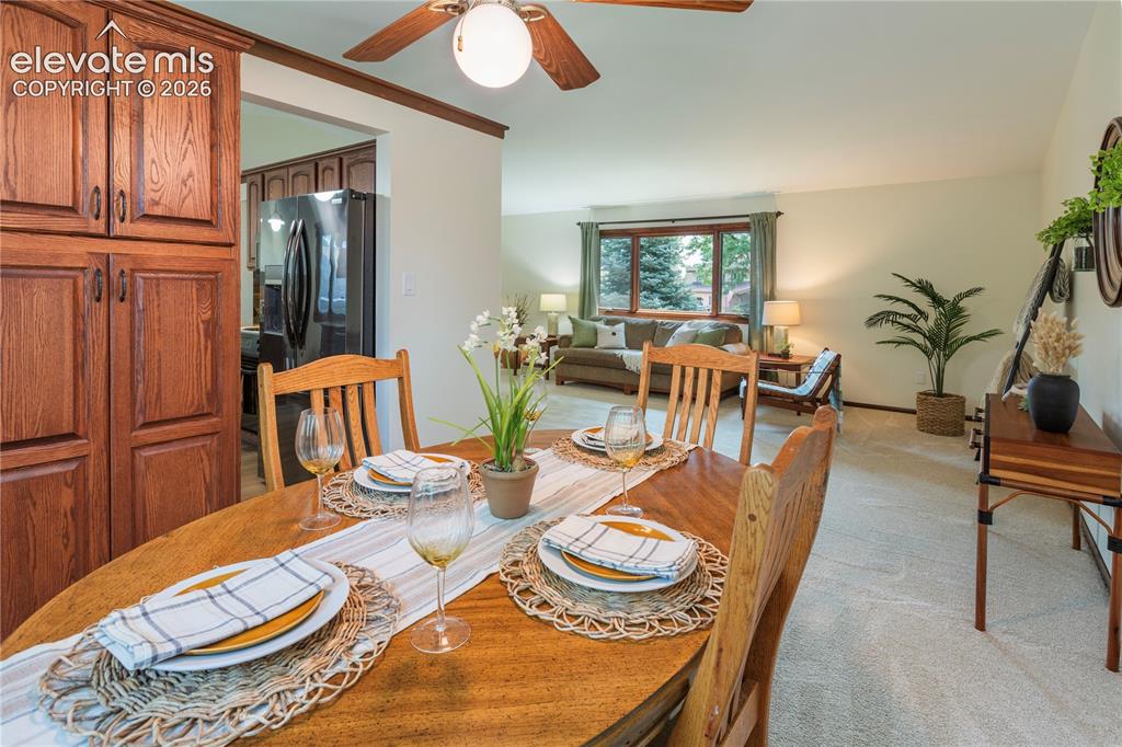 Image 26 of 50: Dining area with a ceiling fan and built-in storage cabinets.