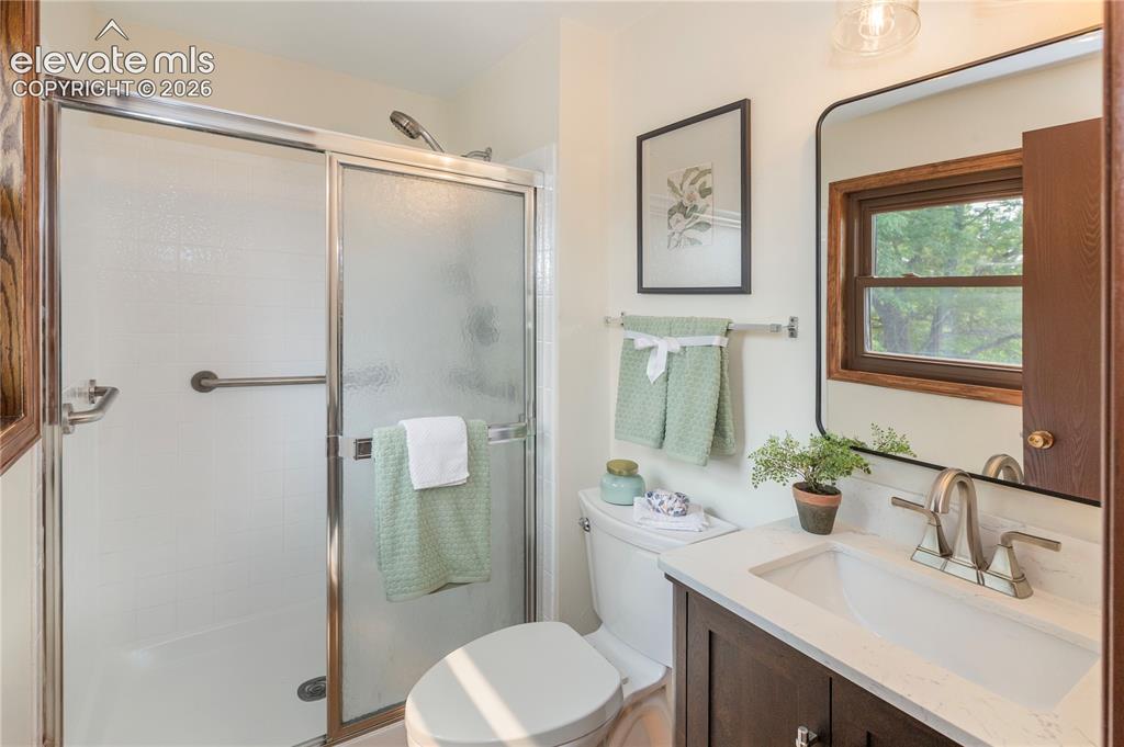 Image 34 of 50: Updated primary bath with LVP flooring, new wood vanity with marble counter