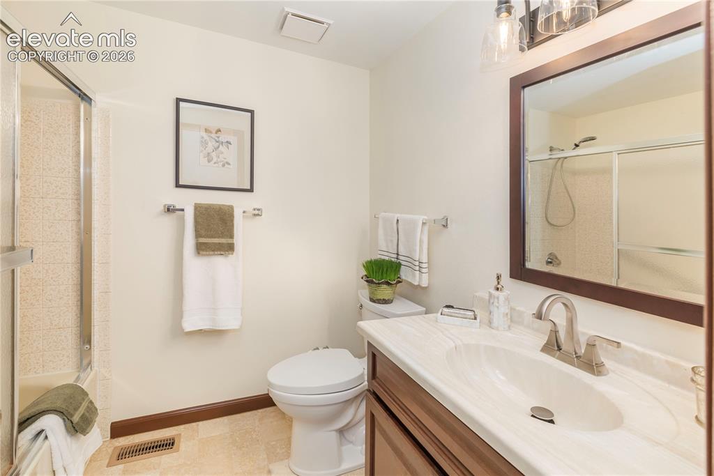Image 37 of 50: Hall bathroom features a tub/shower combination with sliding glass door, va
