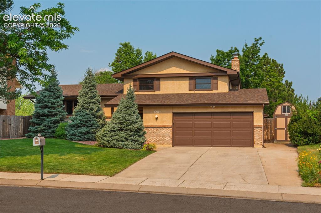 Image 5 of 50: Expanded driveway with side storage shed.