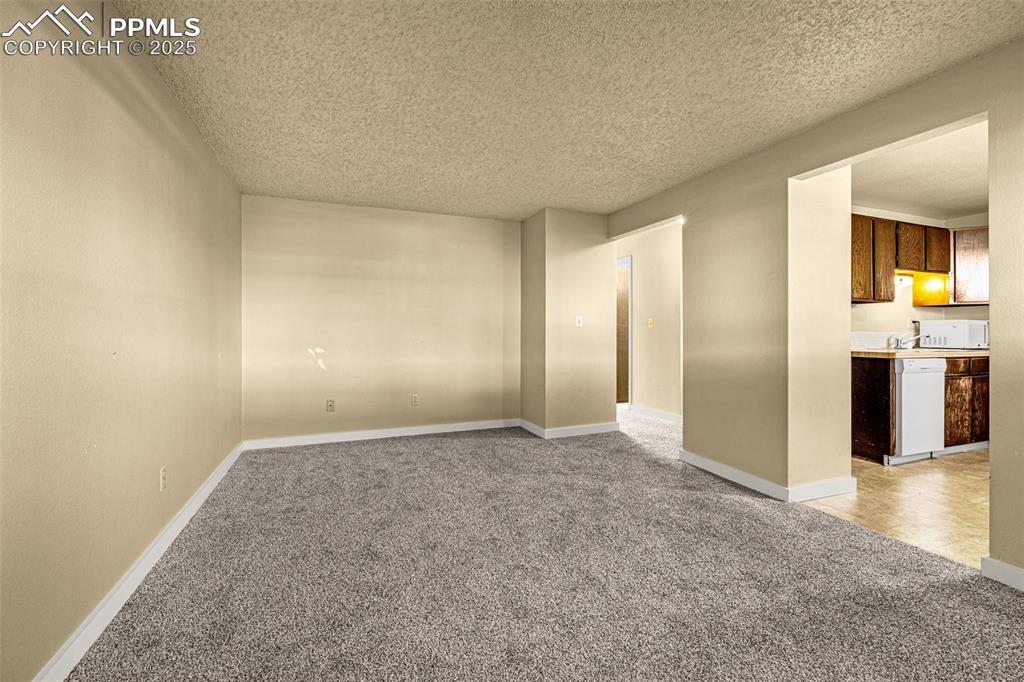 Image 5 of 15: Empty room featuring light carpet and a textured ceiling