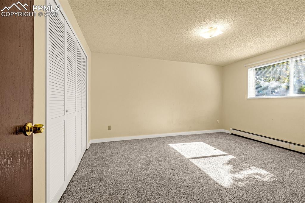Image 9 of 15: Unfurnished bedroom featuring a closet, carpet, and a textured ceiling
