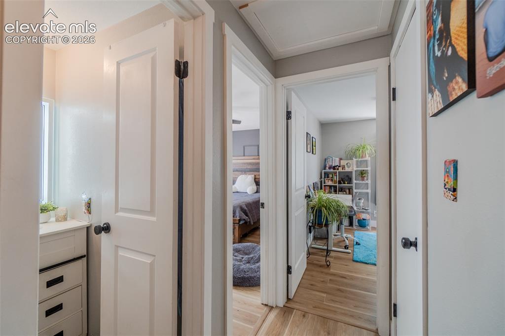 Image 15 of 31: Hallway featuring three panel doors, a built-in three-drawer vanity, and wo