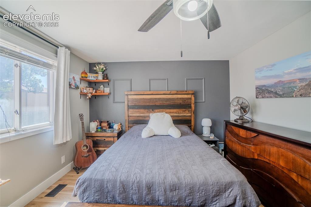 Image 18 of 31: Bedroom featuring wood-finish flooring, a window with blinds, a ceiling fan