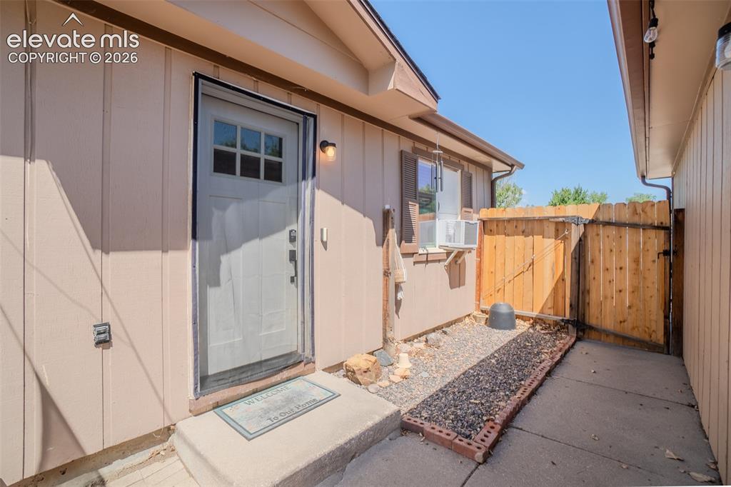 Image 2 of 31: Exterior Entry featuring a new gate. Exterior wall lighting, a window-mount
