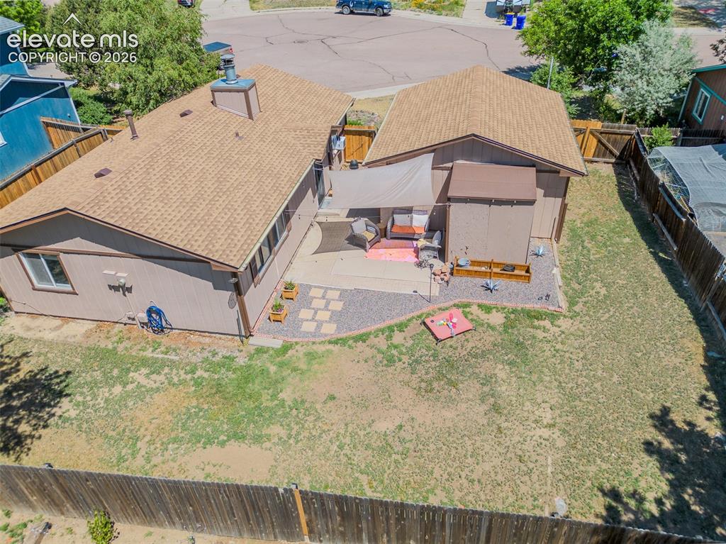 Image 22 of 31: Expansive backyard featuring a large patio, gravel landscaping, and a priva