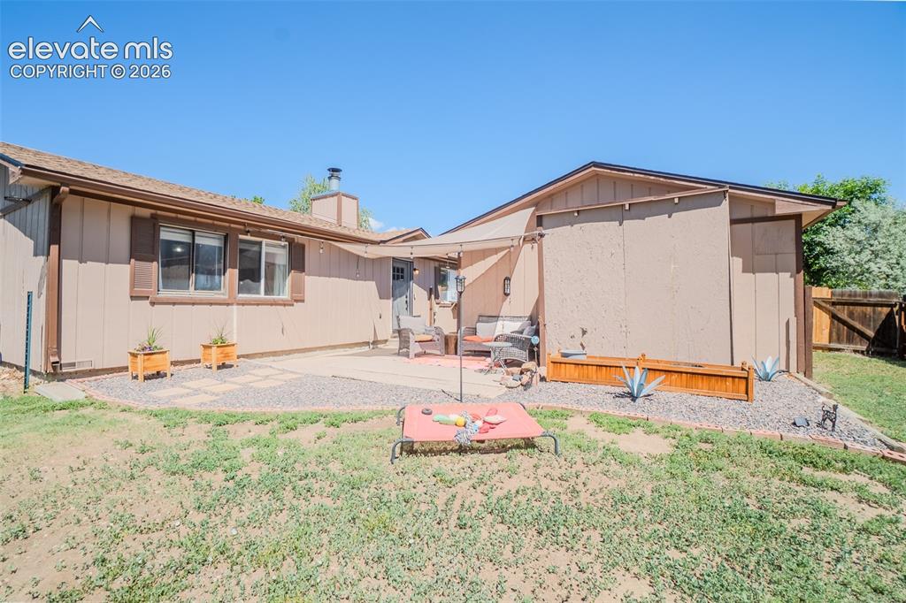 Image 23 of 31: Private backyard featuring a concrete patio, gravel landscaping, and a part