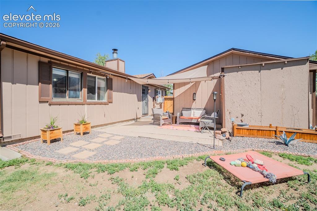 Image 26 of 31: Outdoor patio area featuring a shade sail, concrete pavers, and decorative