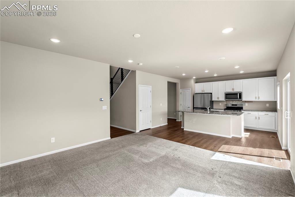 Image 10 of 43: Kitchen with white cabinets, open floor plan, recessed lighting, stainless 